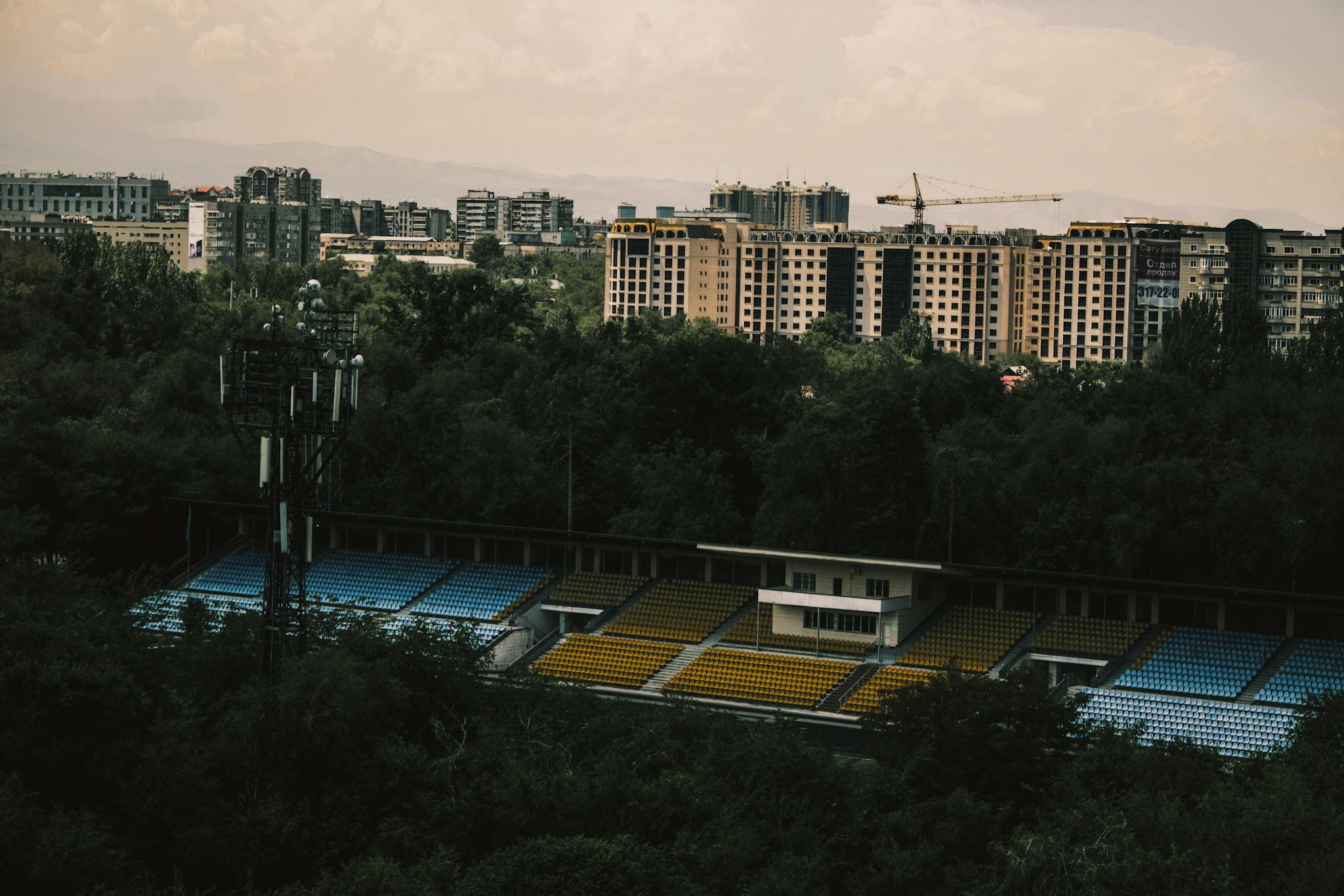 Aerial view of a stadium surrounded by a vibrant urban cityscape with trees.