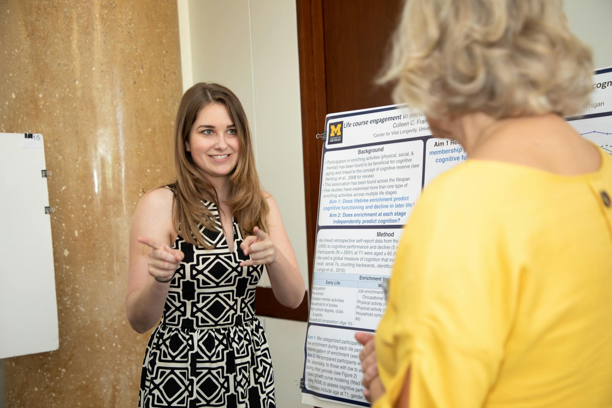 Young woman presenting research at an academic conference to a fellow attendee.